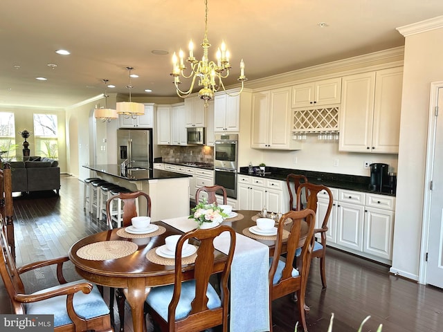 dining area with arched walkways, dark wood finished floors, and ornamental molding