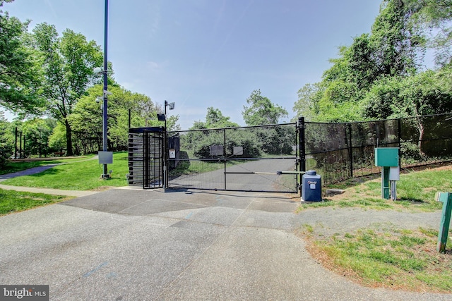 view of gate with fence and a yard