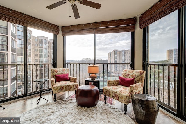 sunroom featuring a view of city and a ceiling fan