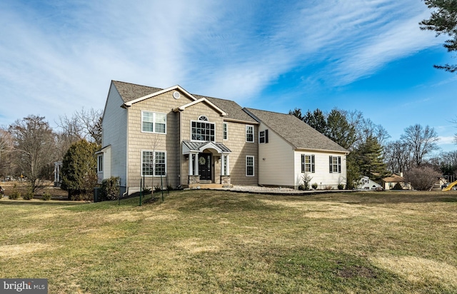 traditional-style house with a shingled roof and a front yard