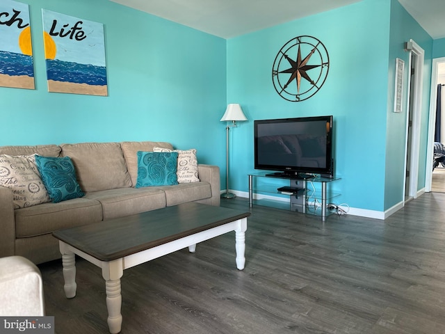 living area with baseboards and wood finished floors