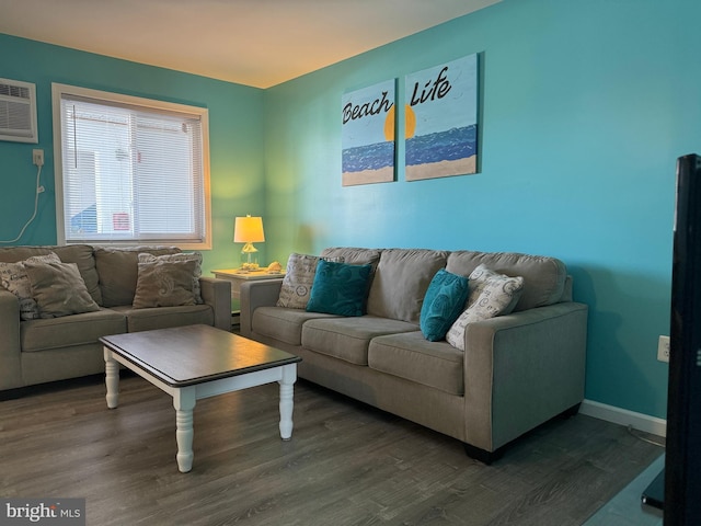 living room with a wall unit AC, baseboards, and wood finished floors