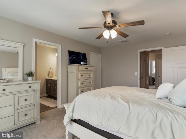 bedroom featuring light carpet, ceiling fan, visible vents, and ensuite bathroom