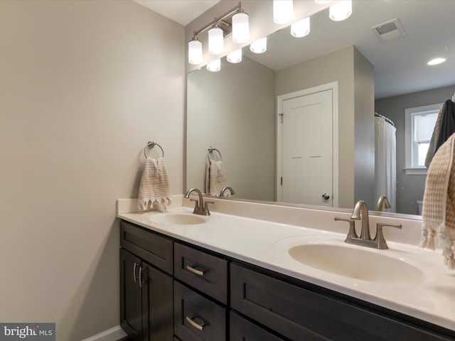 full bath with double vanity, visible vents, and a sink