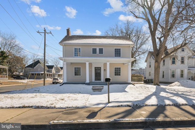 view of front facade with a chimney and a porch