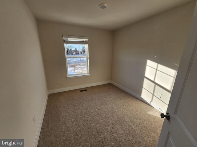 carpeted empty room with visible vents and baseboards