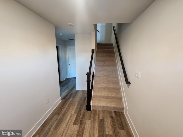 staircase with wood finished floors and baseboards