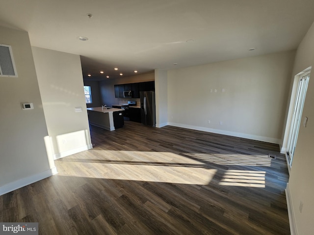 interior space with dark wood-style floors, visible vents, and baseboards