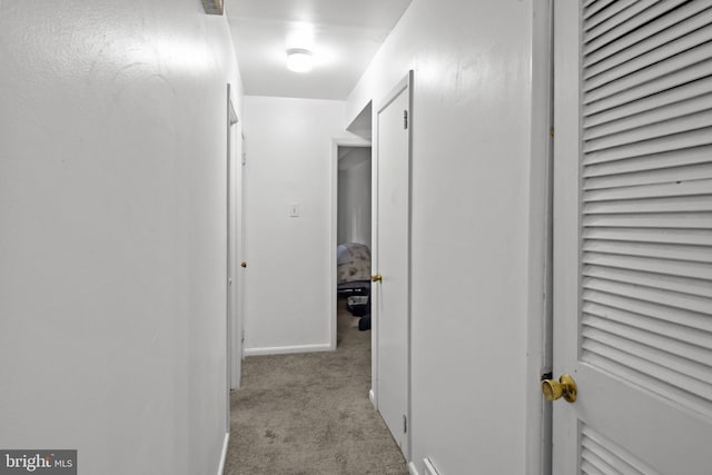 corridor with light carpet and baseboards