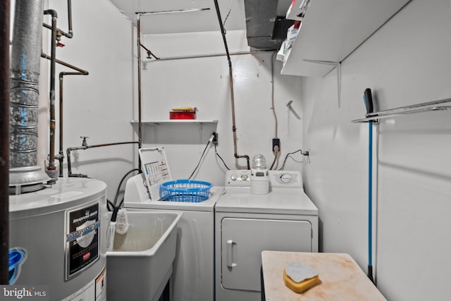 washroom with laundry area, water heater, separate washer and dryer, and a sink