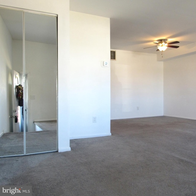 empty room with ceiling fan, carpet, visible vents, and attic access