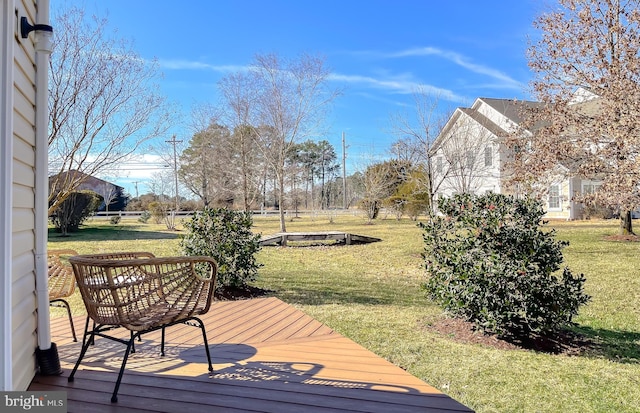 wooden terrace featuring a lawn