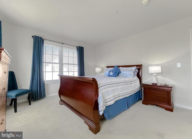 bedroom featuring light carpet and baseboards