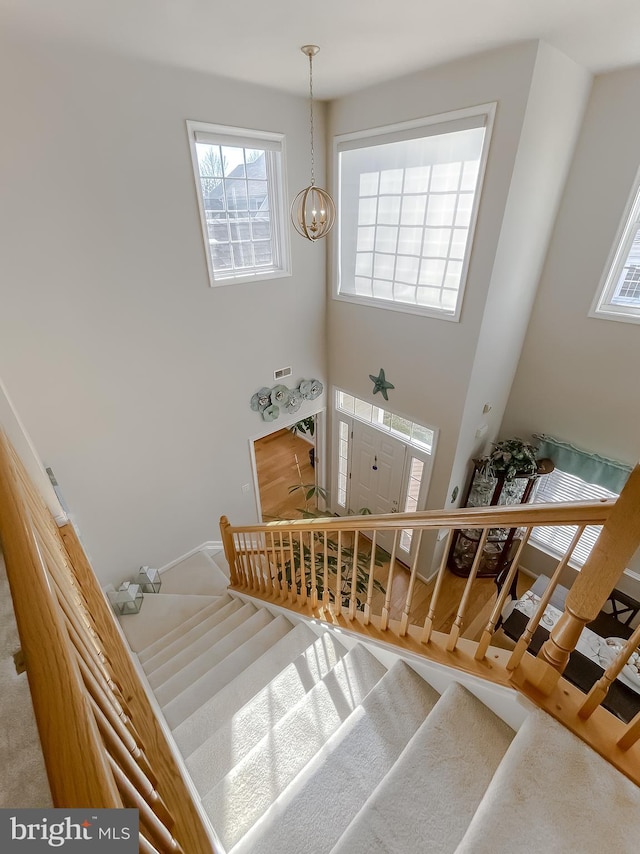 stairs with an inviting chandelier