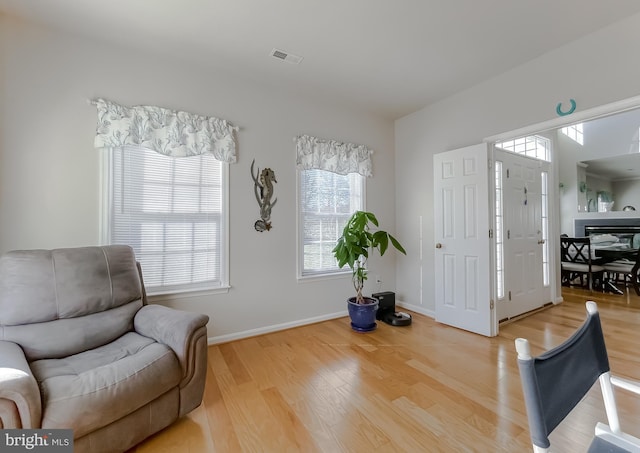 living area with visible vents, baseboards, and wood finished floors