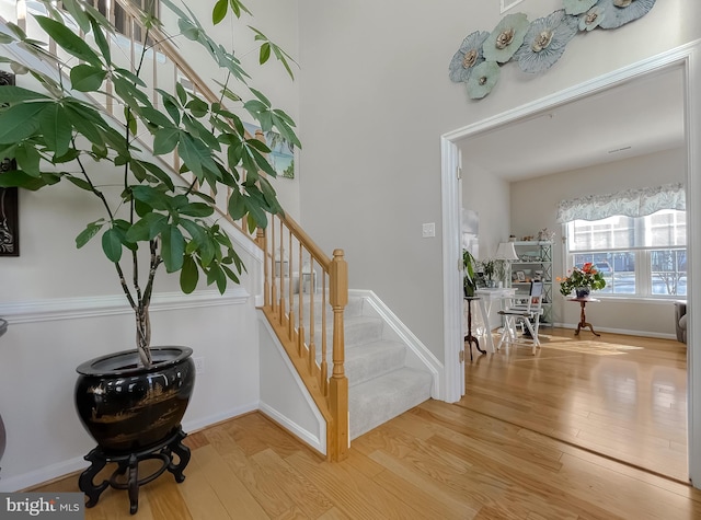 staircase featuring wood finished floors and baseboards