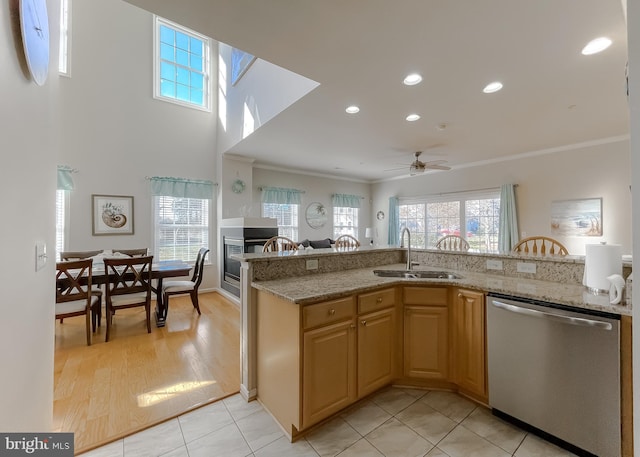 kitchen with crown molding, a sink, stainless steel dishwasher, and light stone countertops