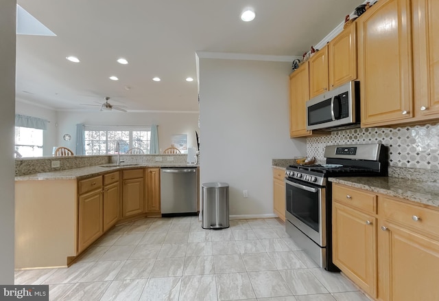 kitchen featuring light stone countertops, crown molding, appliances with stainless steel finishes, and a sink