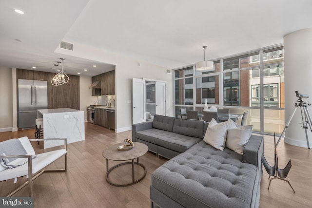 living area with light wood finished floors, baseboards, visible vents, and recessed lighting