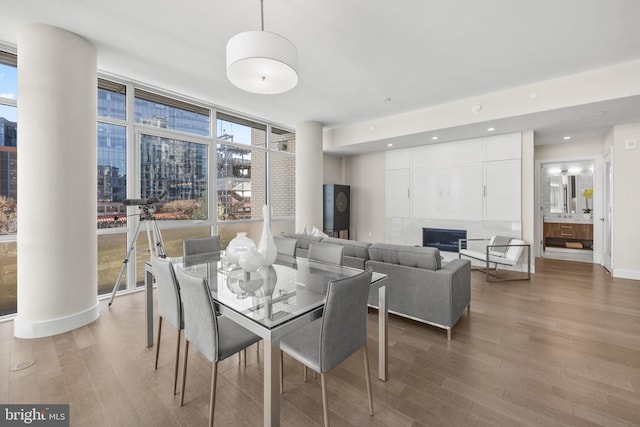 dining area with expansive windows, baseboards, wood finished floors, and recessed lighting