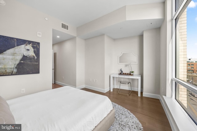 bedroom with dark wood-style flooring, visible vents, and baseboards