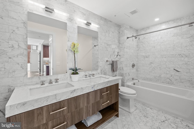 bathroom with toilet, visible vents, tub / shower combination, and a sink