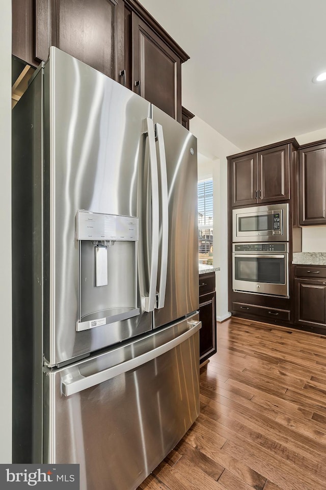 kitchen with dark brown cabinets, appliances with stainless steel finishes, and wood finished floors