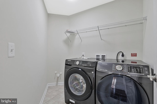 laundry room with baseboards, laundry area, and washer and dryer