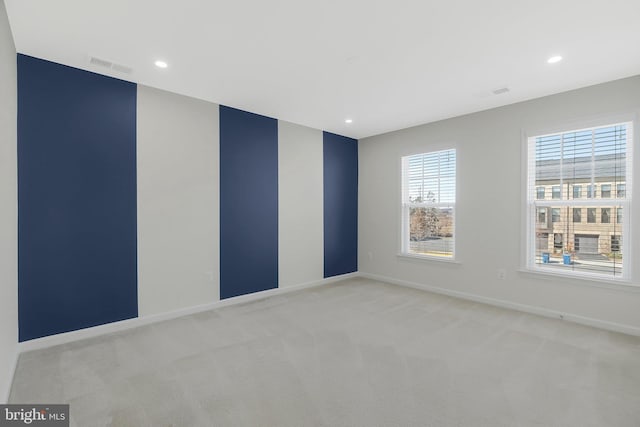 empty room with light carpet, recessed lighting, visible vents, and baseboards