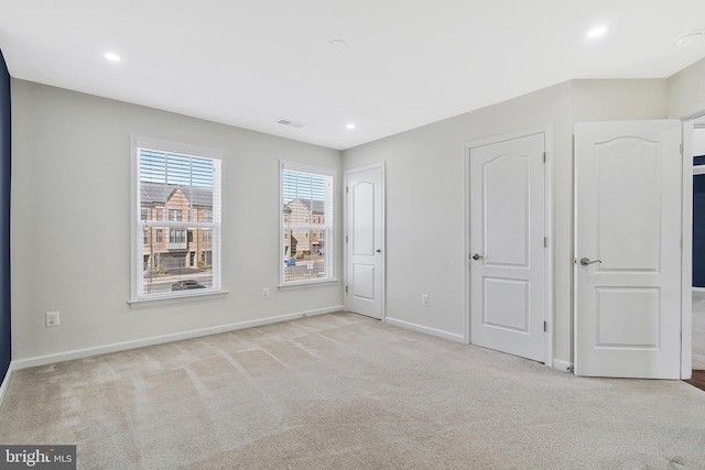 unfurnished bedroom featuring light carpet, visible vents, baseboards, and recessed lighting