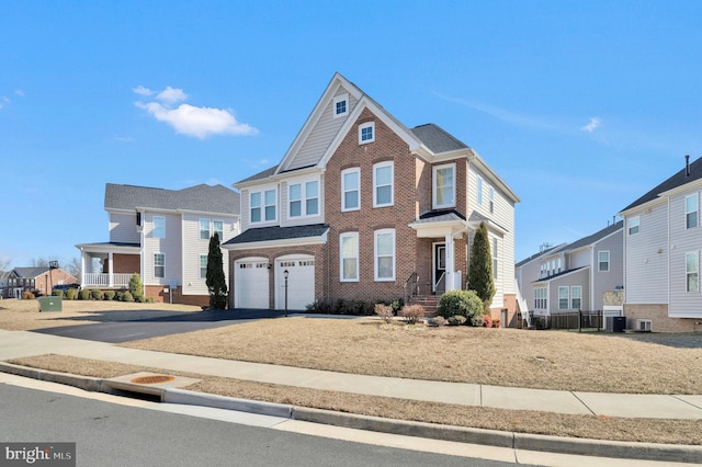 view of front of property with a garage, a residential view, aphalt driveway, and brick siding