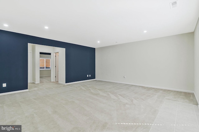 empty room with light colored carpet, visible vents, baseboards, and recessed lighting