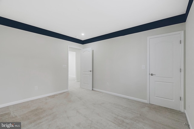 empty room featuring baseboards, recessed lighting, and light colored carpet