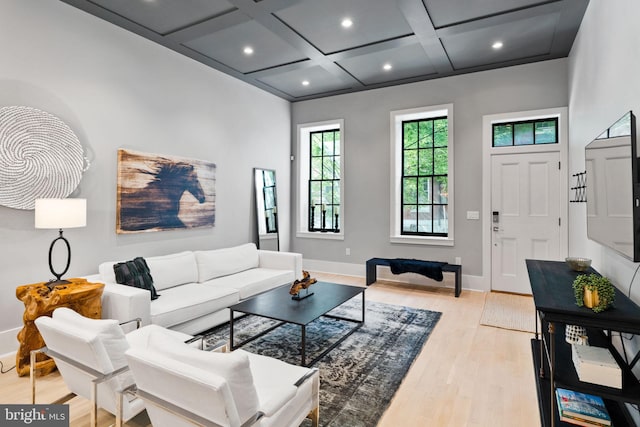 living room featuring baseboards, coffered ceiling, light wood-style flooring, beam ceiling, and recessed lighting