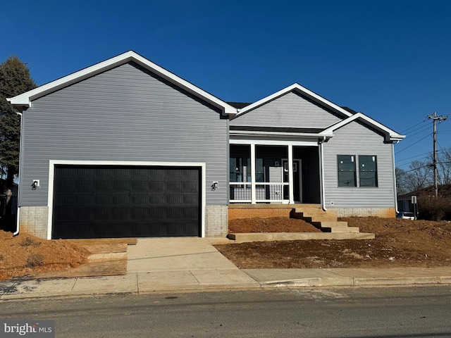 view of front of property featuring concrete driveway and a garage