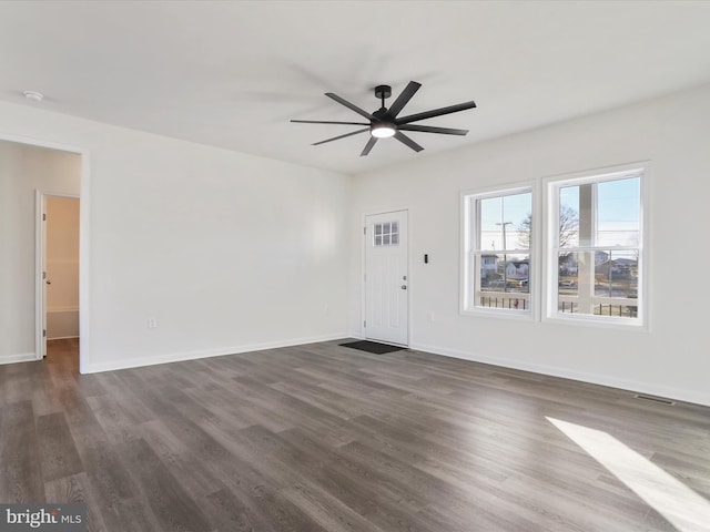 interior space with dark wood-type flooring, visible vents, baseboards, and ceiling fan