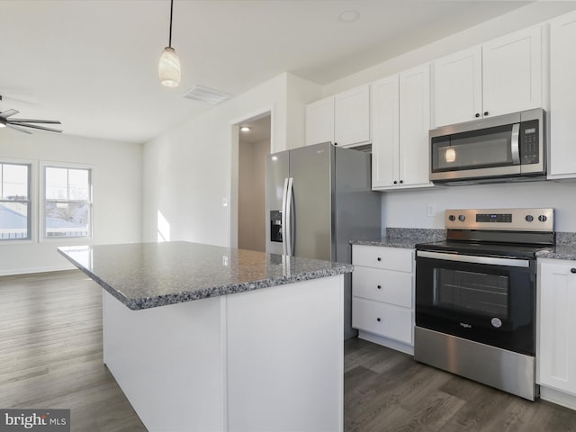 kitchen with dark wood-style floors, visible vents, a kitchen island, stainless steel appliances, and white cabinets