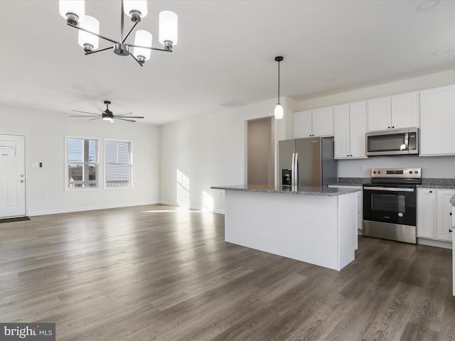 kitchen with pendant lighting, a kitchen island, white cabinetry, stainless steel appliances, and dark wood-style flooring