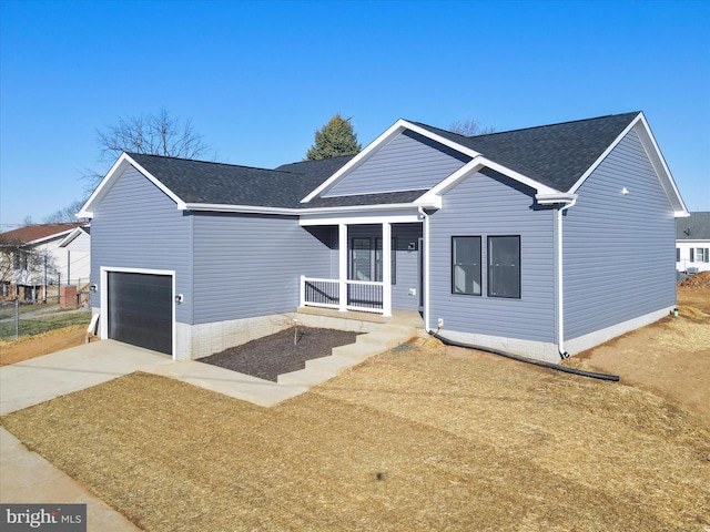 ranch-style home featuring concrete driveway, an attached garage, covered porch, and roof with shingles