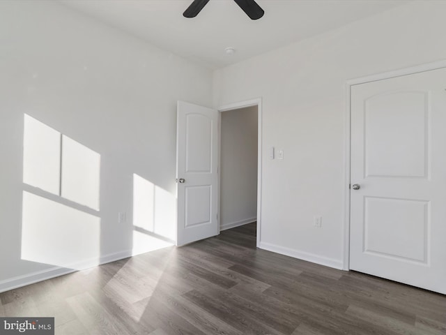 empty room with a ceiling fan, wood finished floors, and baseboards