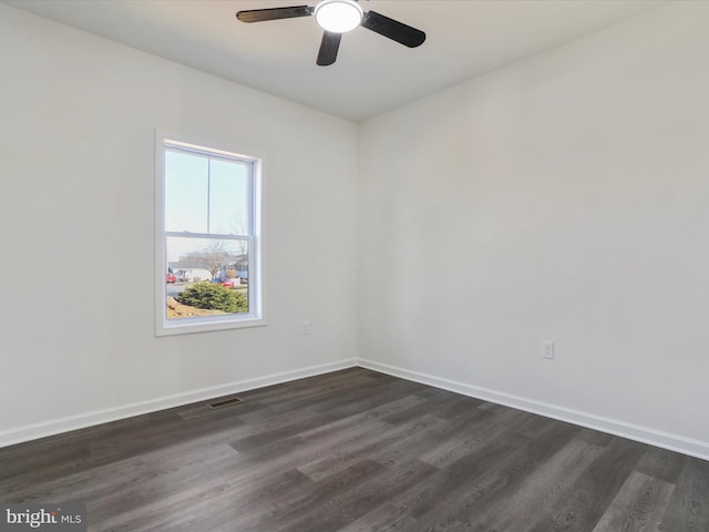 unfurnished room featuring dark wood-type flooring and baseboards