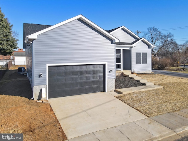 ranch-style house with a garage, brick siding, central AC, and driveway