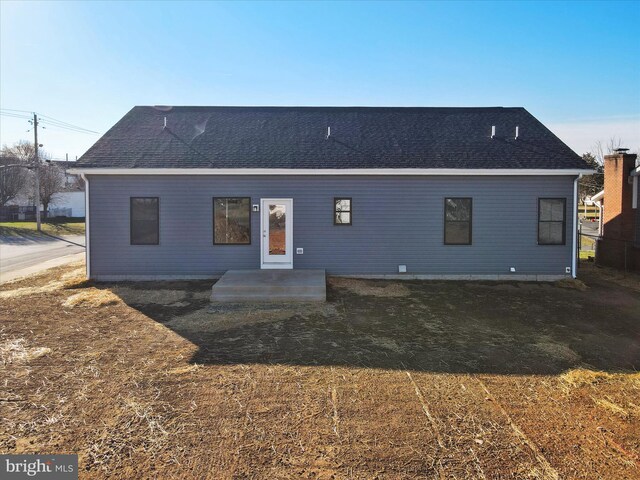 rear view of house with a shingled roof