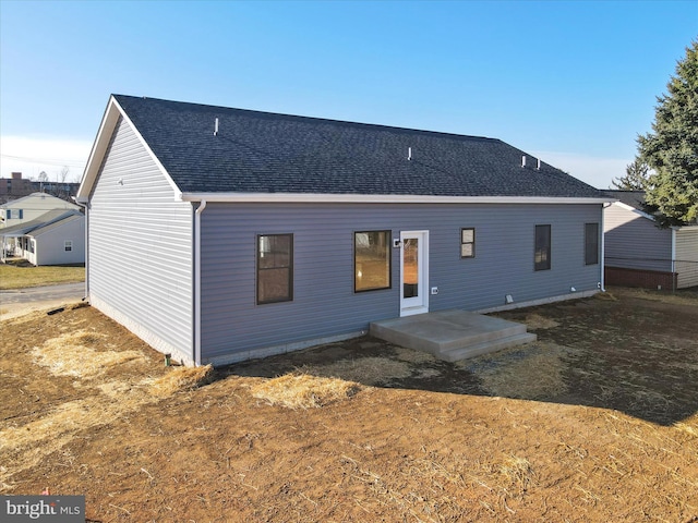 rear view of house featuring a shingled roof