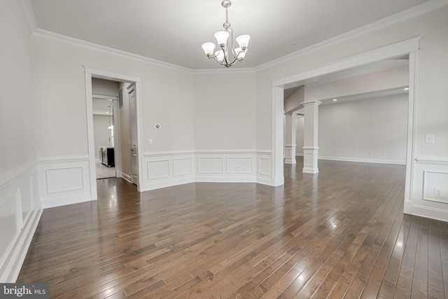 unfurnished room with dark wood-type flooring, crown molding, a notable chandelier, and ornate columns