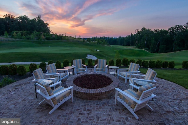 view of patio / terrace with view of golf course and an outdoor fire pit