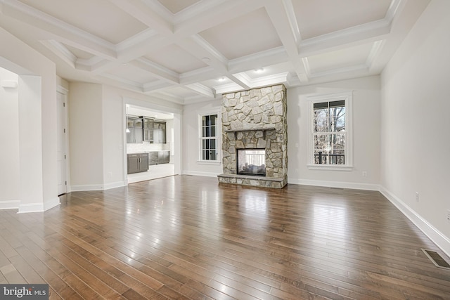 unfurnished living room featuring beam ceiling, visible vents, dark wood-style flooring, and a stone fireplace