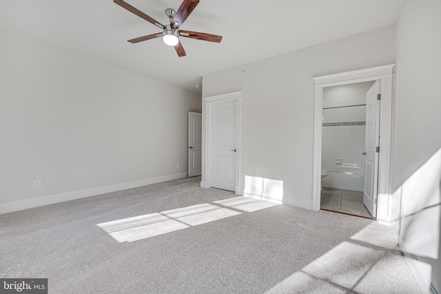 unfurnished bedroom with baseboards, ceiling fan, connected bathroom, and light colored carpet