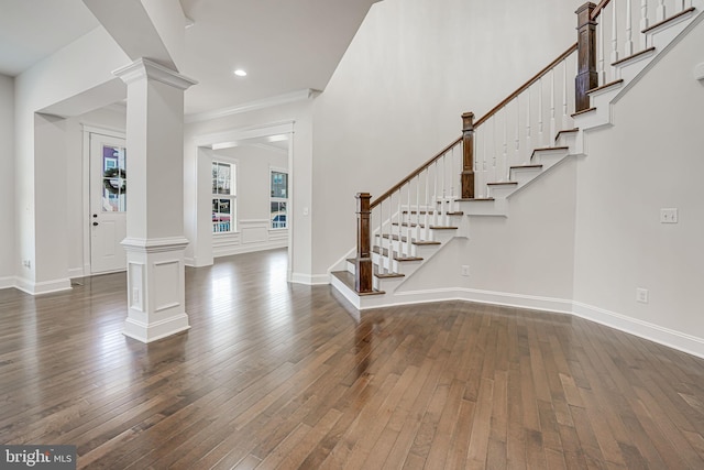 entrance foyer with baseboards, decorative columns, stairway, and dark wood-style flooring