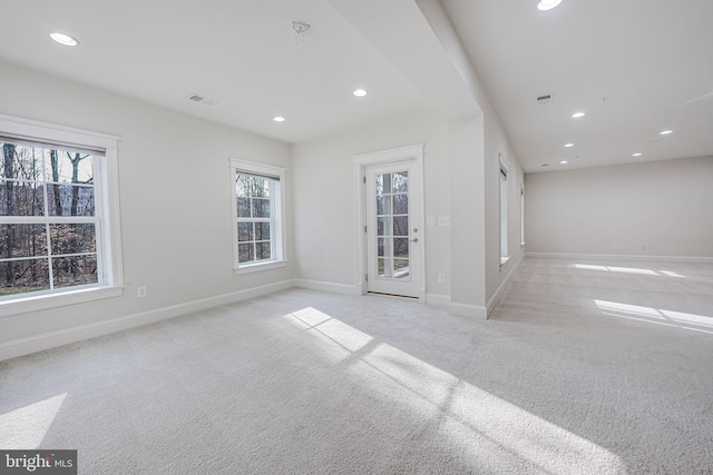 spare room with recessed lighting, light colored carpet, visible vents, and baseboards